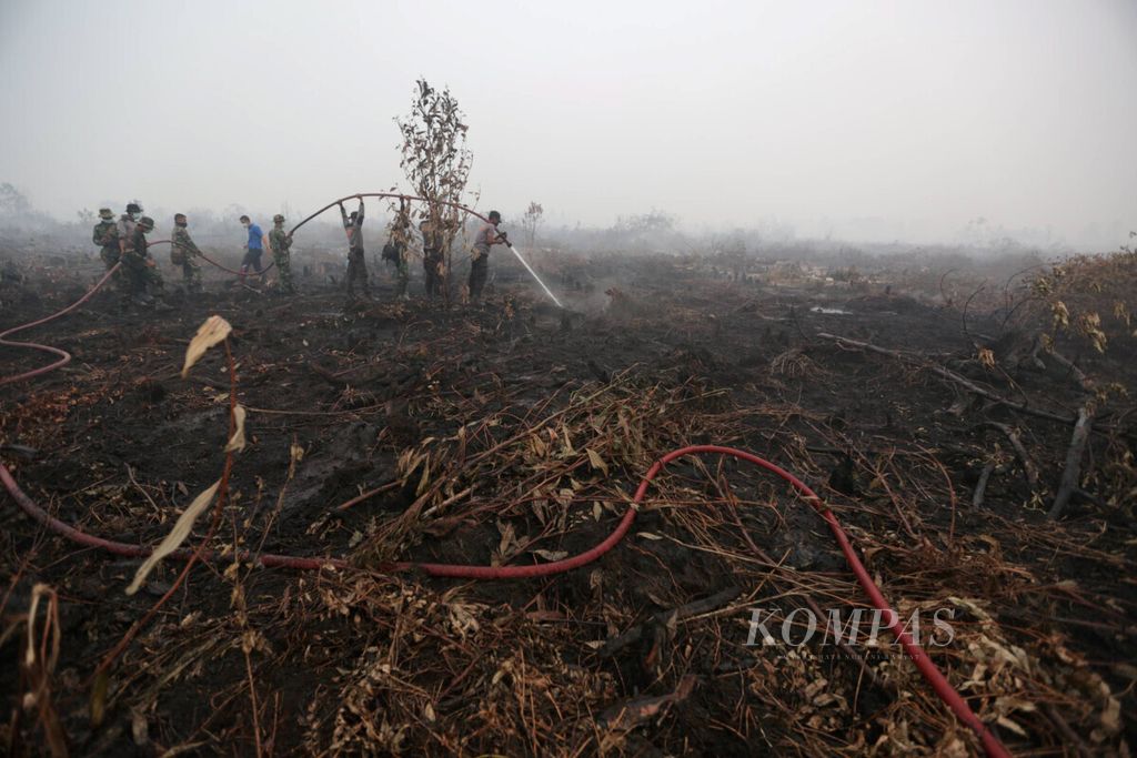 Petugas gabungan berusaha memadamkan kebakaran lahan gambut di Desa Rimbo Panjang, Kecamatan Tambang, Kabupaten Kampar, Riau, Sabtu (5/9/2015).