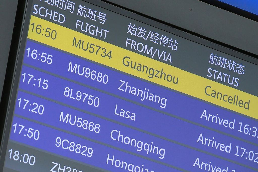 Papan informasi digital di bandara internasional Kunming Changshui di Yunnan memperlihatkan status salah satu penerbangan China Eastern pada Senin (21/3/2022).