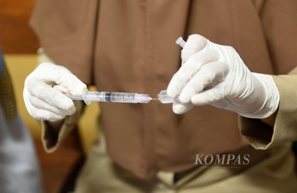 Petugas menyiapkan vaksin mesles rubela (MR) di Madrasah Ibtidaiyah (MI) Al Karim, Surabaya, Jawa Timur, Selasa (20/9/2022). Imunisasi dilakukan oleh tenaga medis dari Puskesmas Sidosermo. Untuk kelas I mendapatkan imunisasi measles rubela (MR) dan siswa perempuan kelas V dan VI mendapatkan imunisasi human papillomavirus (HPV). Sebanyak 400 siswa dari dua sekolah di Kelurahan Sidorsermo mendapatkan imunisasi. 