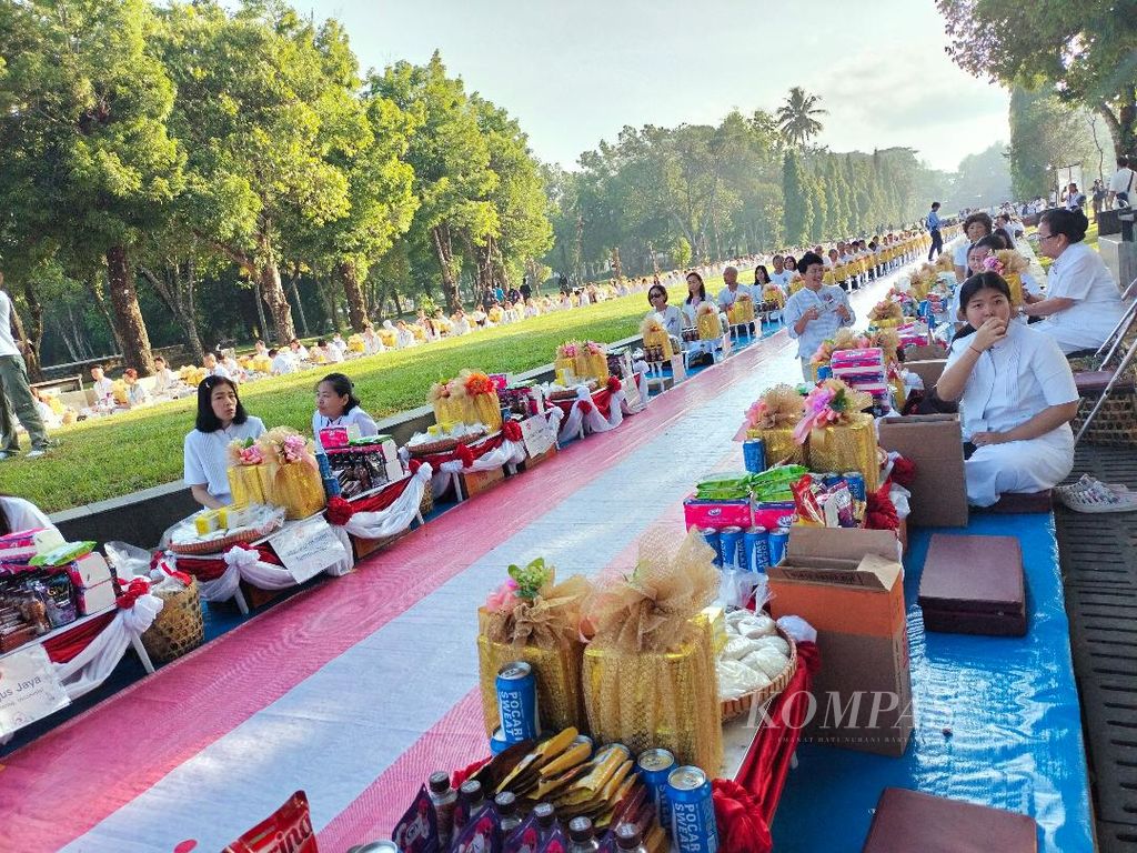 Deretan umat Buddha bersiap memberikan derma kepada para samanera sementara yang akan melintas dalam acara pindapata di Taman Wisata Candi Borobudur, Kabupaten Magelang, Jawa Tengah, Rabu (20/12/2023).