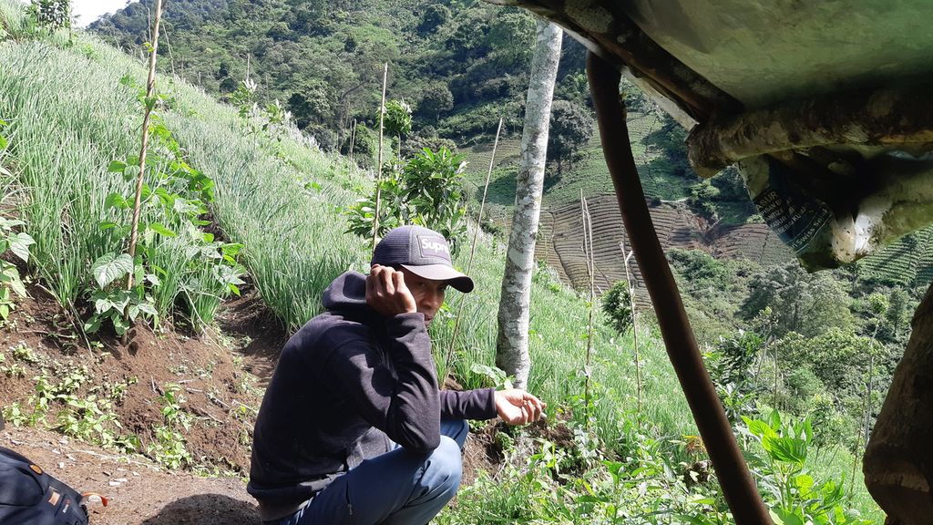 HN (33) duduk di saung dekat lahan hasil perambahan yang dia lakukan di area Gunung Rakutak, bagian Cagar Alam Kawah Kamojang, Kabupaten Bandung, Jawa Barat, Sabtu (28/5/2022). Sudah sekitar setahun terakhir, HN merambah area hutan konservasi bersama petani-petani lain.
