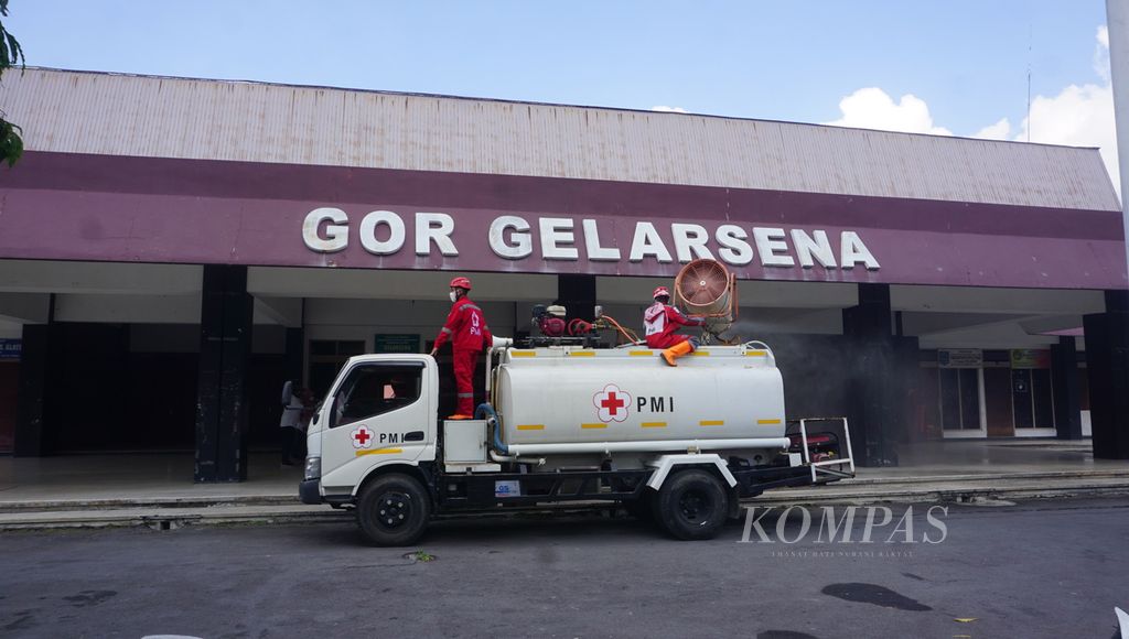 Petugas PMI menyemprotkan disinfektan pada bangunan GOR Gelarsena di Kabupaten Klaten, Jawa Tengah, Rabu (28/7/2021). Gedung tersebut dijadikan tempat isolasi terpusat bagi pasien Covid-19 tanpa gejala.