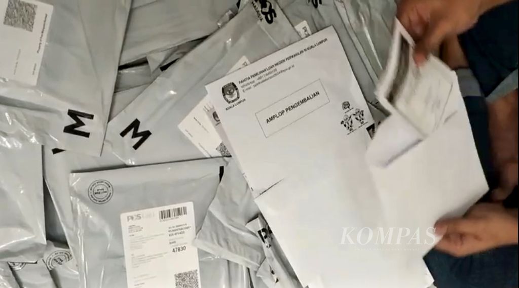 Tangkapan layar seseorang membuka amplop pengembalian berisi surat suara bagi pemilih dengan metode pos yang diduga terjadi di Kuala Lumpur, Malaysia.