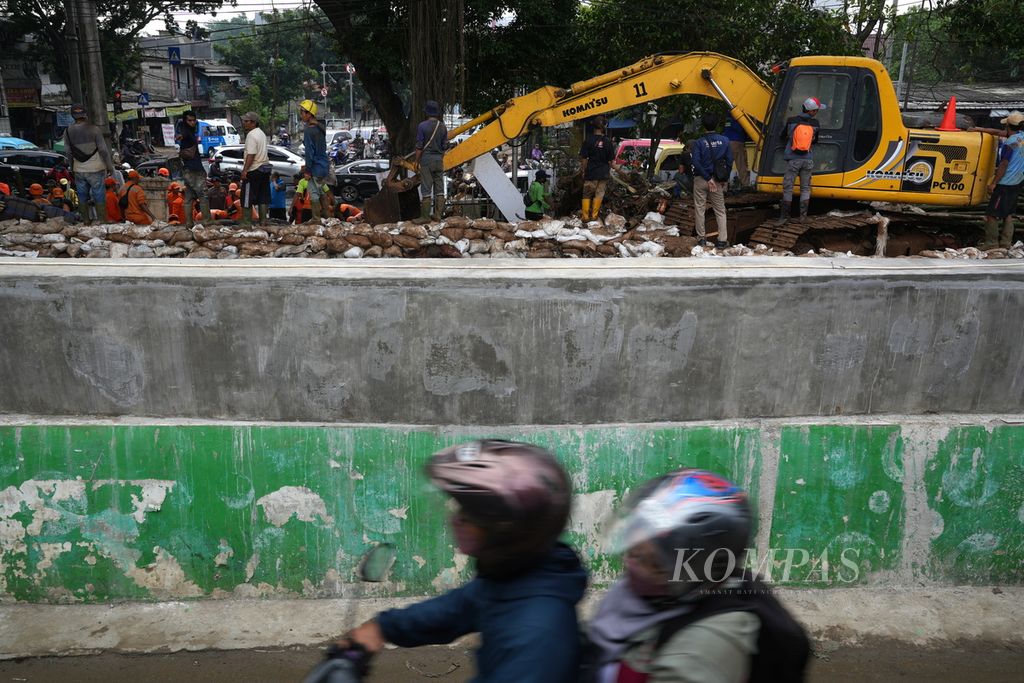 Petugas gabungan dalam penanganan tanggul Kalibaru yang jebol di Simpang Hek, Kramatjati, Jakarta Timur, Senin (25/3/2024). 