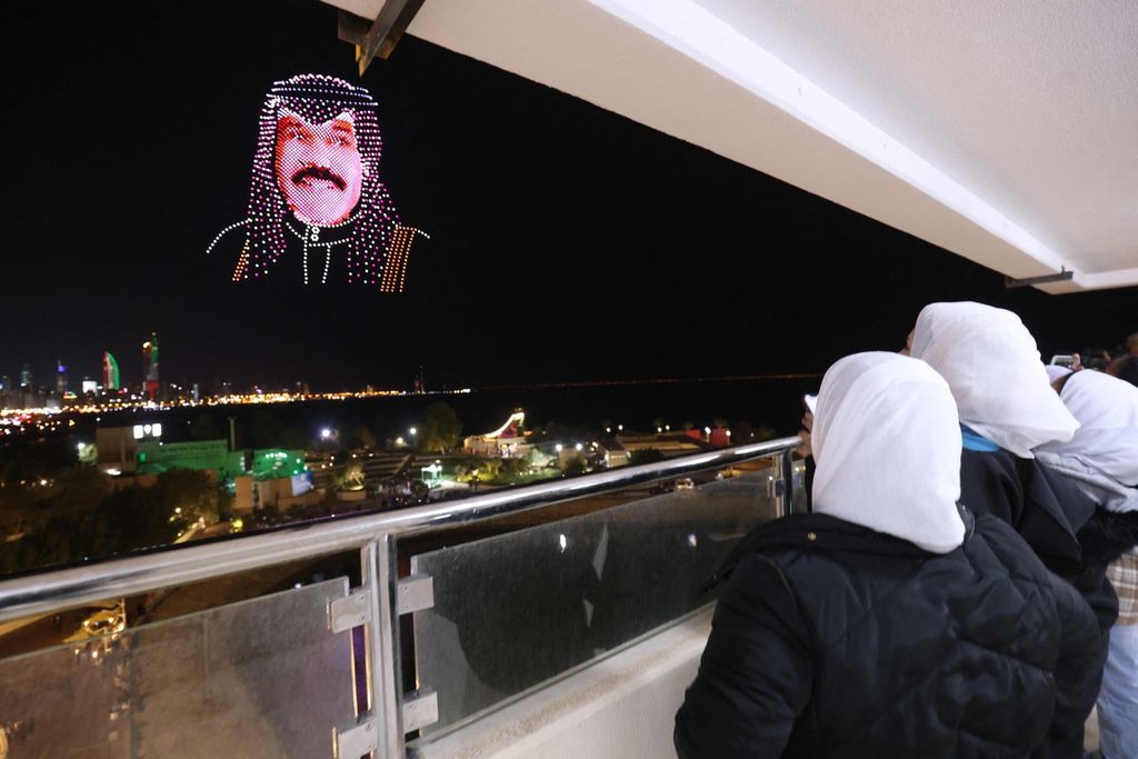 Warga menyaksikan gambar wajah Emir Kuwait Nawaf al-Ahmad al-Jaber al-Sabah yang dibuat dengan pesawat nirawak (<i>drone</i>) di angkasa, di atas Green Island, lepas pantai Kuwait City, Kuwait, 16 Februari 2023. 