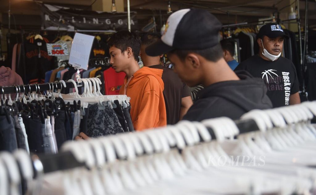 Warga memilih celana panjang saat datang ke bazar pakaian bekas (<i>thrifting</i>) di gedung bekas Giant Diponegoro, Surabaya, Jatim, Minggu (9/6/2023). Tren membeli pakaian bekas terus tinggi hingga saat ini.  