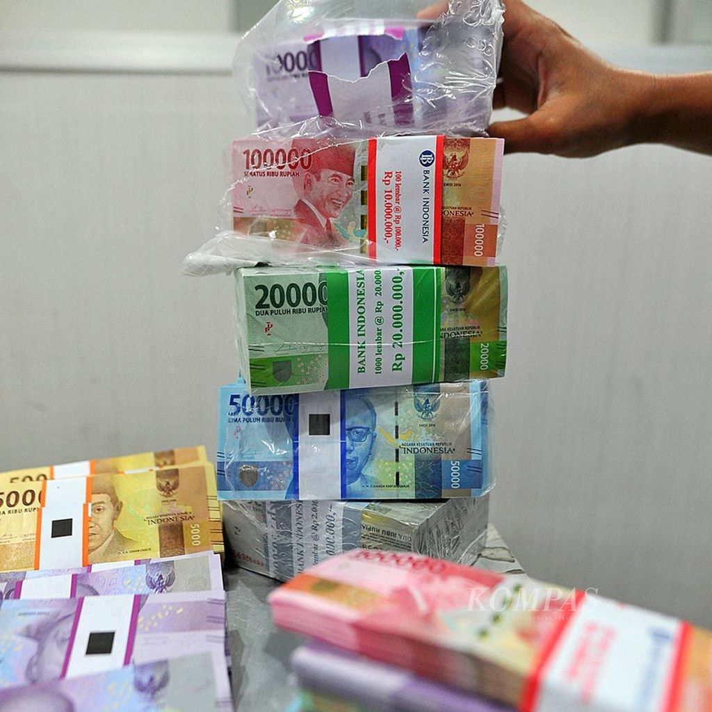 An officer shows a number of rupiah notes issued for 2016 at the cash management unit of PT Bank Mandiri (Persero) Tbk, Jakarta, on Tuesday (30/5/2016).