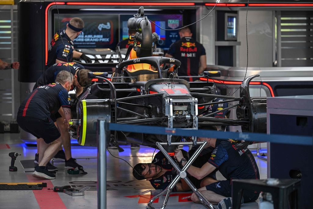 Mekanik tengah bekerja menangani mobil pebalap Red Bull Racing, Sergio Perez, jelang balapan Formula 1 seri Singapura, Kamis (14/9/2023).
