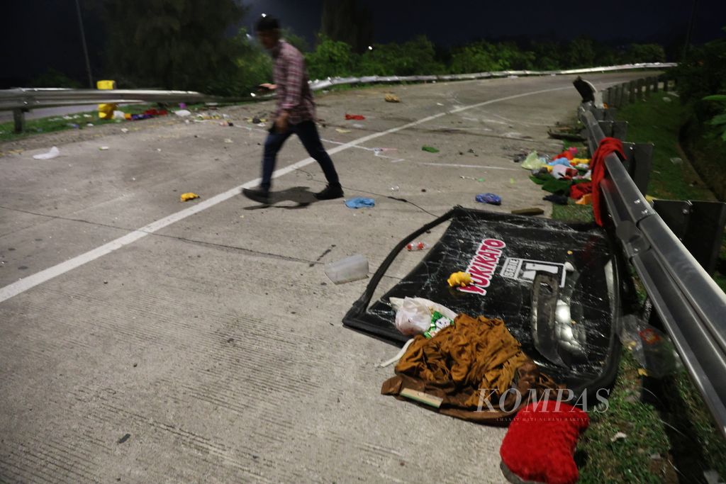 Sisa-sisa barang penumpang bus berserakan di lokasi terjadinya kecelakaan di ruas Tol Cikampek-Purwakarta, Jawa Barar, Jumat (15/12/2023). Kecelakaan tunggal ini mengakibatkan 12 orang tewas. 