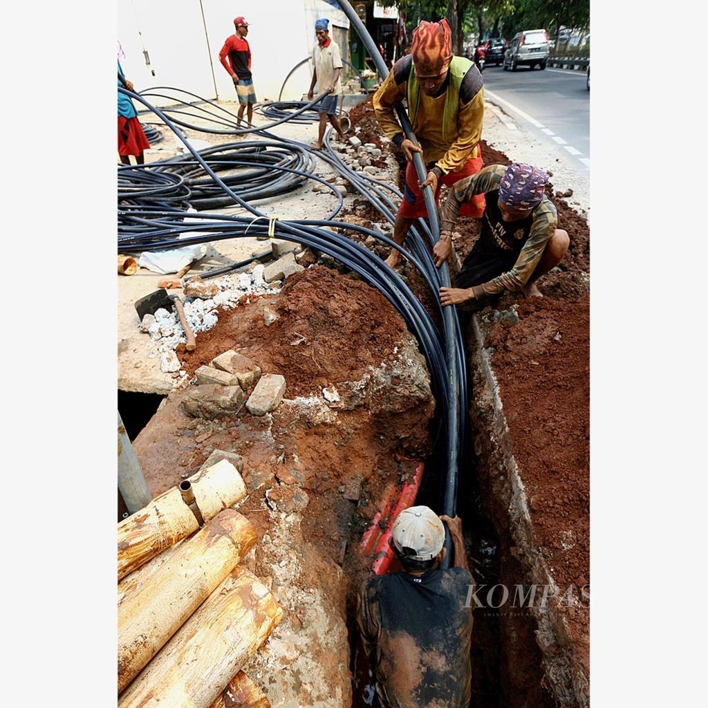 Pekerja menanam pembungkus kabel jaringan internet di Jalan Panjang, Jakarta Barat, Kamis (23/8/2018). Berdasarkan survei Asosiasi Penyelenggara Jasa Internet Indonesia (APJII), jumlah pengguna internet di Indonesia tahun 2017 mencapai 143,26 juta jiwa.