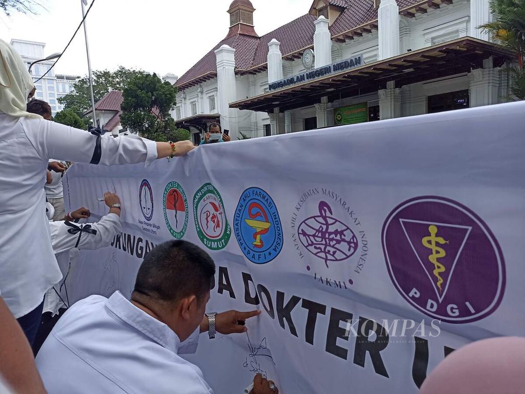 Para dokter melakukan unjuk rasa di depan Pengadilan Negeri Medan, Sumatera Utara, Selasa (14/6/2022). Mereka meminta vaksinator Covid-19 dokter TGA dibebaskan dari dakwaan dalam kasus vaksinasi kosong.