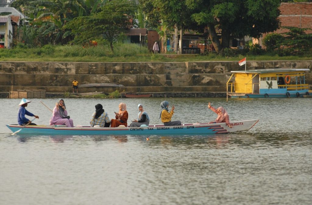 Sejumlah wisatawan berfoto sembari berkeliling kawasan wisata alam Danau Sipin, Kecamatan Telanaipura, Kota Jambi, 2021.