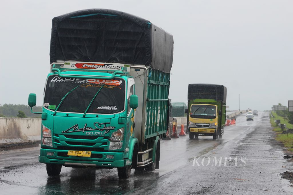 Sejumlah kendaraan dengan muatan berlebih melintas di ruas Tol Trans-Sumatera ruas Kayu Agung-Pematang Panggang-Terbanggi Besar Km 310, Kamis (9/12/2021). Kendaraan ini menjadi salah satu penyebab rusaknya jalan di ruas tol tersebut. Hal ini membuat risiko kecelakaan bagi pengguna tol meningkat.