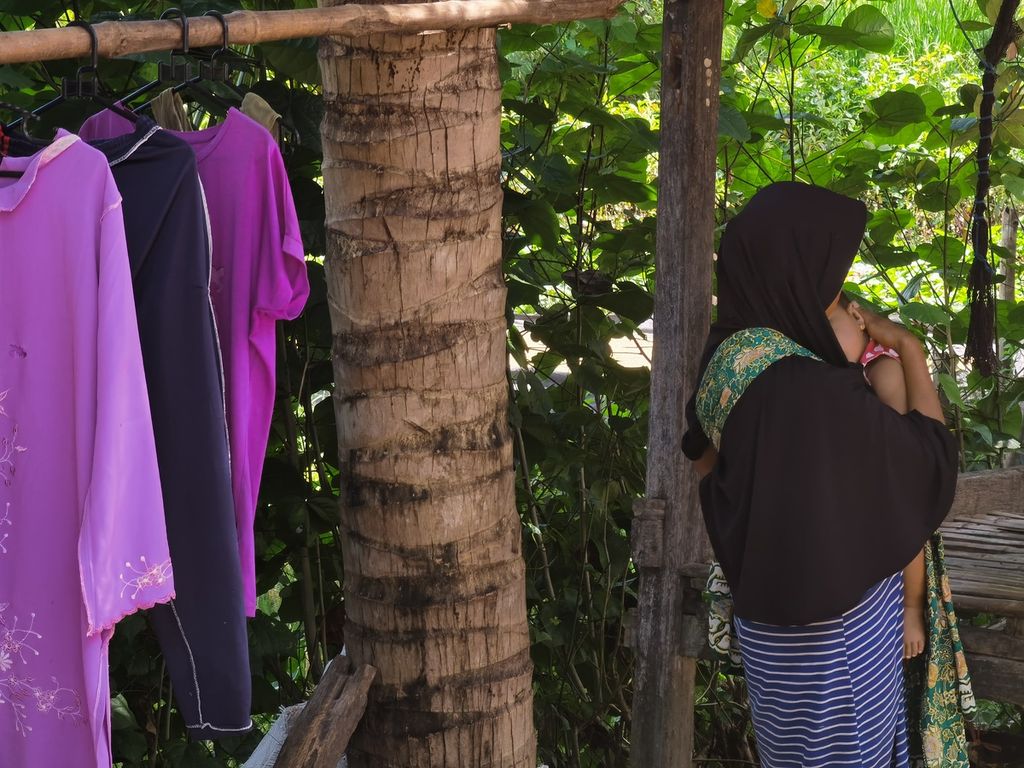 LA (17) menggendong anaknya AAC (8 bulan) di salah satu desa di Lombok Timur, Nusa Tenggara Barat,  April 2021. LA sudah tiga kali menikah dan dua kali bercerai. Pernikahan pertama terjadi saat ia berusia 14 tahun. 