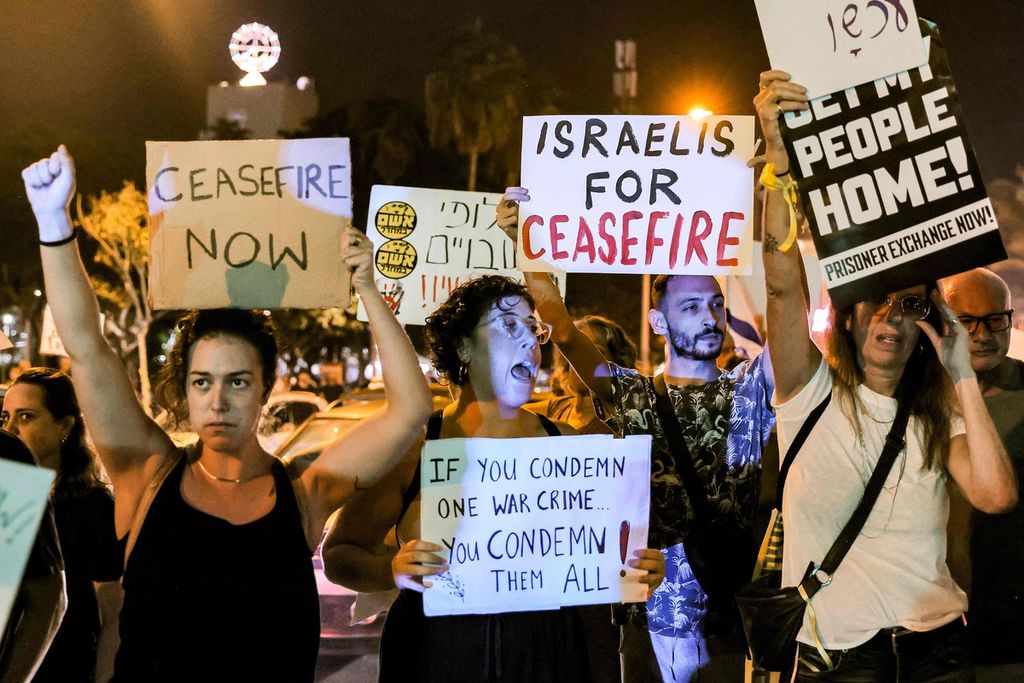 Warga berunjuk rasa di depan Kantor Kementerian Pertahanan Israel di Tel Aviv, Sabtu (28/10/2023) malam. Mereka meminta Israel melakukan gencatan senjata dengan Hamas di Jalur Gaza. Mereka juga meminta Israel mengupayakan pertukaran antara warga Palestina di penjara Israel dengan setidaknya 220 orang yang disandera Hamas di Gaza. 