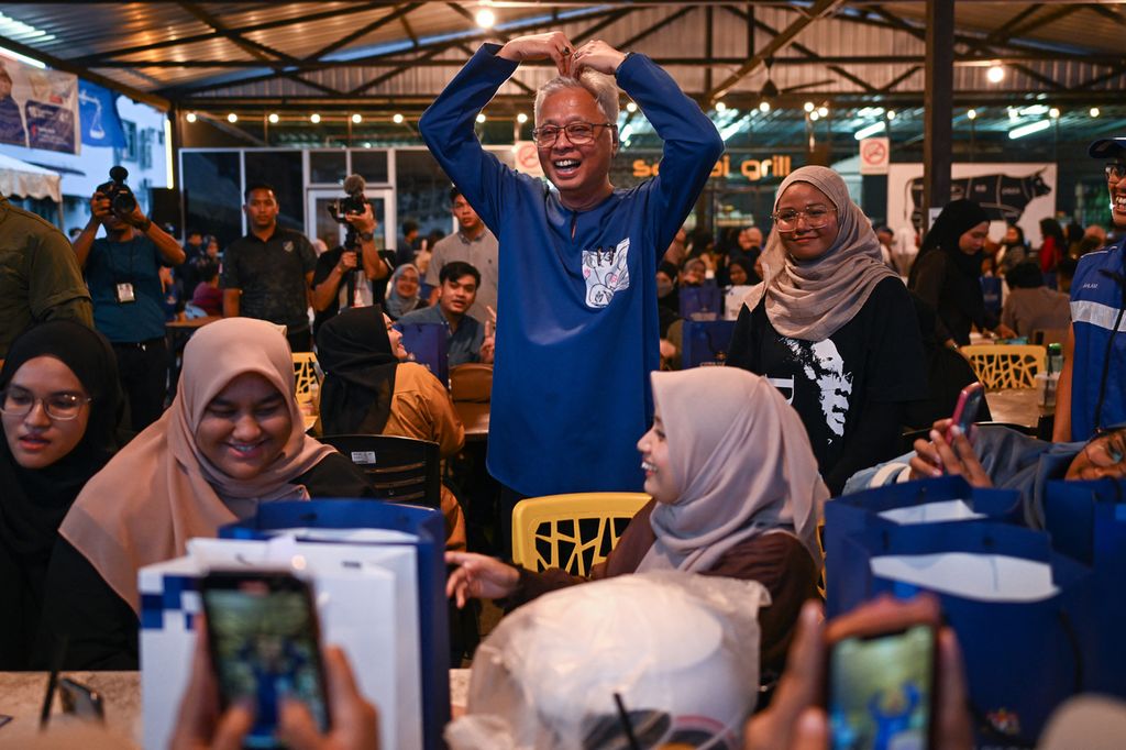 Perdana Menteri Malaysia Ismail Sabri Yaakob (tengah) dan kandidat dari UMNO berpose dengan para mahasiswa di Bera, Pahang, pada malam 18 November 2022, menjelang pemungutan suara keesokan harinya. 