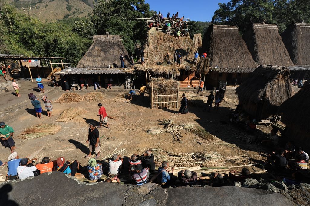 Warga kampung adat Bena bergotong royong memasang atap rumah suku Kopa di Desa Tiworiwu, Kecamatan Jerebu'u, Kabupaten Ngada, Nusa Tenggara Timur, Senin (5/8/2019). Upacara pasang atap rumah dalam bahasa setempat disebut Wae Sao. Upacara diawali dengan tarian Ja'i oleh tuan rumah dan dilanjutkan dengan pemasangan atap. Upacara tersebut diwarnai dengan makan bersama oleh seluruh warga kampung adat. 