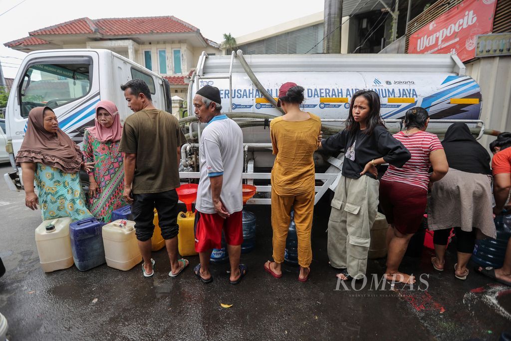Warga menunggu wadah mereka terisi air bersih dari tangki mobil PAM Jaya di Kecamatan Kalideres, Jakarta Barat, Kamis (14/9/2023). Sudah hampir seminggu sebagian warga RW 011, Kelurahan Pegadungan, Kecamatan Kalideres, kesulitan mendapatkan air bersih. Hal itu karena air PAM Jaya tidak mengalir secara maksimal ke rumah warga. Pengadaan mobil tangki air tersebut tidak dipungut biaya. Menurut ketua RW 11, RT yang mengalami krisis air terparah adalah RT 005, RT 006, RT 007, dan RT 010. Warga berharap air PAM yang menjadi sumber utama air warga dapat mengalir secara maksimal.