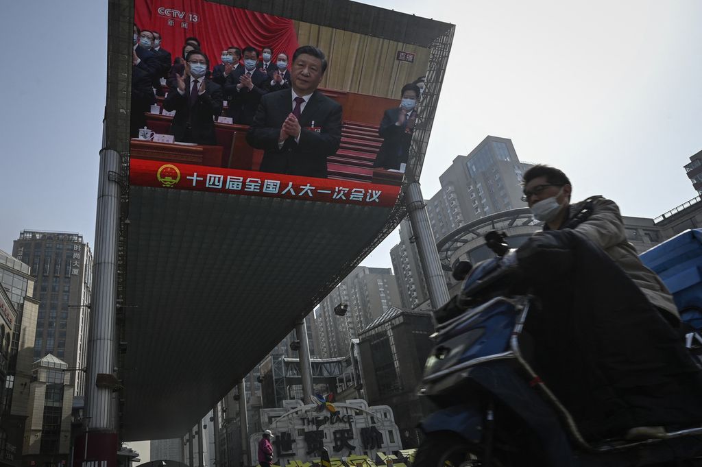 Sebuah layar di luar ruangan menayangkan liputan langsung tentang Presiden China Xi jinping saat Kongres Nasional Rakyat di Aula Besar Rakyat di ruas jalan di Beijing, 10 Maret 2023. 