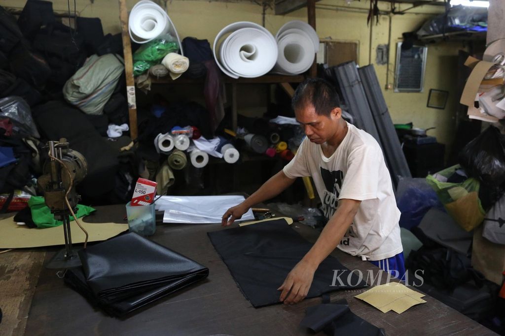 Penjahit di usaha rumah tangga pembuatan perlengkapan pendukung fotografi Artrek menyiapkan bahan saat proses membuat tas di Manggarai, Jakarta, Kamis (27/8/2020). Salah satu program pemulihan ekonomi nasional yang dilakukan pemerintah adalah dengan memberi stimulus dan bantuan produktif kepada para pelaku UMKM.