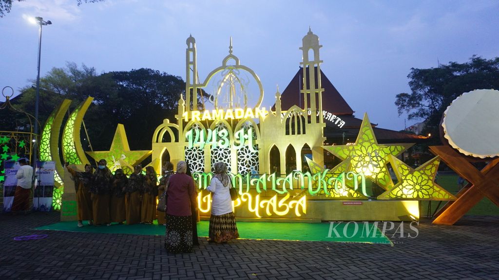 Warga berswafoto di depan hiasan lampu berbentuk masjid dalam rangka ”Semarak Ramadan 2022” di Kota Surakarta, Jawa Tengah. Acara tersebut bertujuan untuk menyemarakkan Ramadhan di kota tersebut.