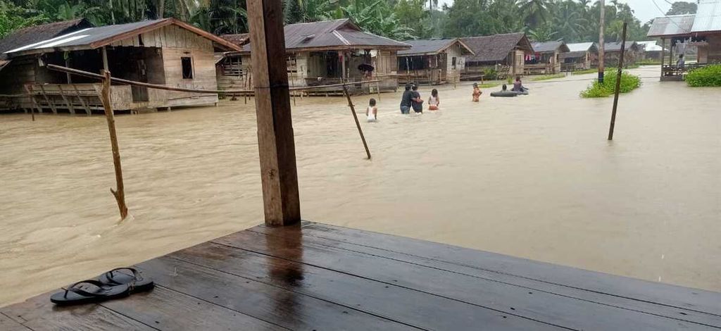 Warga beraktivitas di tengah banjir yang menggenangi Desa Malancan, Kecamatan Siberut Utara, Kepulauan Mentawai, Sumatera Barat, Minggu (13/11/2022). Ada sekitar 222 keluarga terdampak banjir di tiga dusun di desa ini.