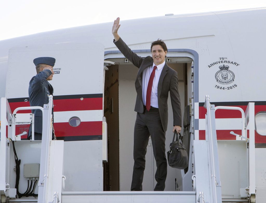 Perdana Menteri Kanada Justin Trudeau memasuki pesawat di Bandar Udara Internasional Ottawa, Jumat (5/5/2023), untuk terbang ke London, Inggris, guna menghadiri upacara penobatan Raja Charles III. 