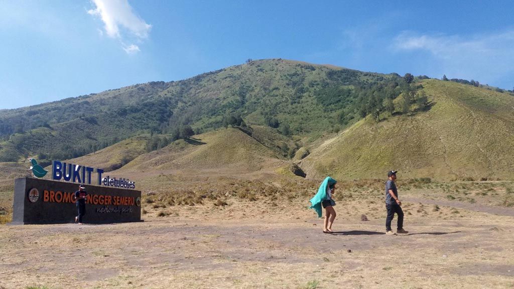 Wisatawan melintas di depan tugu ikonik di kawasan bukit teletubies Gunung Bromo, Jawa Timur, Sabtu (14/10). Pembangunan tugu ikonik tersebut diprotes oleh beberapa kalangan karena dinilai merusak keelokan pemandangan alam di sana.