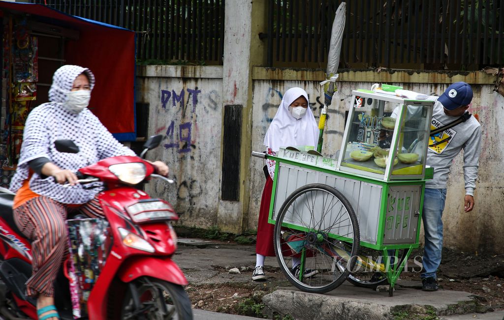 Seorang siswa membeli jajanan saat pulang sekolah di kawasan Joglo, Kembangan, Jakarta Barat, akhir Januari 2021.  