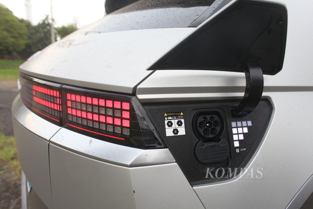 Soket pengisi daya baterai pada Hyundai Ioniq 5 terletak di sisi kanan belakang mobil, lengkap dengan indikator kapasitas baterai.
