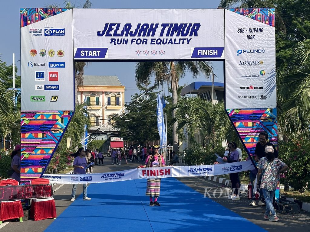 Pelari Anita Krisnandari (54) dari #BuatIndonesiaBergerak mengenakan kain tenun NTT saat mencapai garis finis lari amal ultramaraton Jelajah Timur 2023 kategori ekshibisi 10K di Kantor Gubernur NTT di Kota Kupang, Sabtu (28/10/2023). 