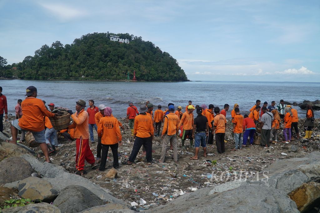 Para petugas bergotong royong mengangkat sampah dari obyek wisata Pantai Padang, Padang, Sumatera Barat, Sabtu (29/4/2023).