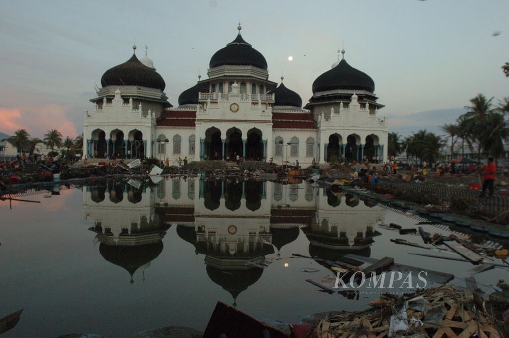 Kolam di depan Masjid Baiturrahman memantulkan puing yang berserakan akibat sapuan gempa dan tsunami di Banda Aceh, Provinsi Nanggroe Aceh Darussalam, Selasa (28/12/2004).