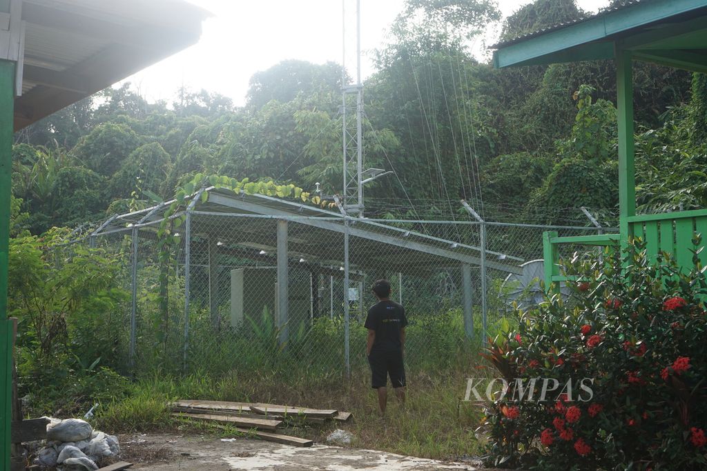 Seorang warga berdiri di sekitar menara BTS 4G di Desa Long Peleban, Kecamatan Peso, Kabupaten Bulungan, Kalimantan Utara, Senin (23/10/2023). Menara yang dibangun dari program Bakti Kemenkominfo itu hanya bisa digunakan dua hari dan setelahnya tak bisa digunakan sama sekali.
