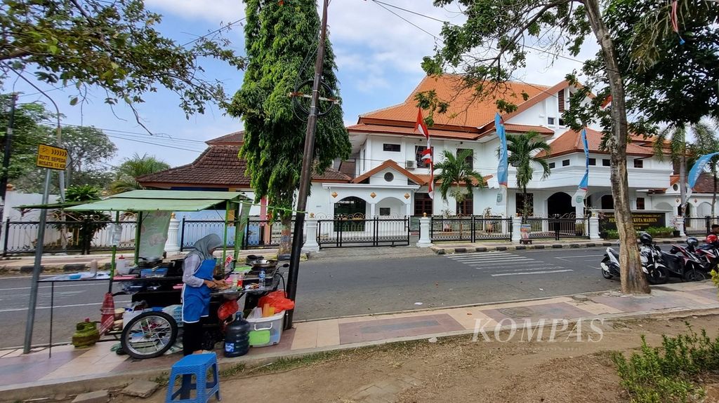 Pedagang berjualan di depan Pusat Pelatihan dan Pendidikan Pemerintah Kota Madiun, Jawa Timur, Sabtu (22/7/2023). Di tengah kompetisi, gedung itu menjadi mes bagi pemain PSM Madiun.