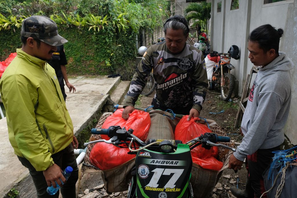 Sejumlah anggota aliansi komunitas sepeda motor trail TAAB menyiapkan sembako di Desa Cijedil, Kecamatan Cugenang, Kabupaten Cianjur, Jawa Barat, yang akan dibagikan ke pengungsi gempa di Kampung Dangdeur, Desa Sukaresmi, Kecamatan Sukaresmi, Kabupaten Cianjur, Rabu (30/11/2022). 