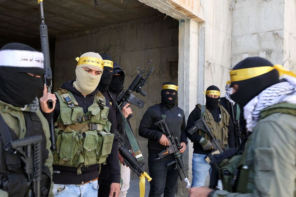 Para anggota ”Brigade Martir Abu Ammar” (alias Yasser Arafat), bagian dari Brigade Martir Al-Aqsa yang berafiliasi pada gerakan Fatah, berdiri dengan membawa senapan dalam upacara pemakaman anggota kelompok Jihad Islam, Shaas Kamamji, di Desa Kafr Dan, Jenin barat, wilayah pendudukan Tepi Barat, Kamis (14/4/2022).