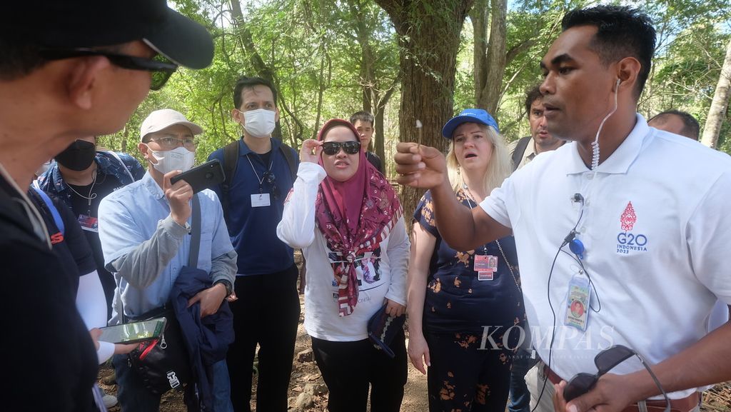 Rombongan delegasi Sherpa G20 mendengarkan penjelasan dari pemandu wisata saat menyusuri jalur <i>trekking</i> di Pulau Komodo, Manggarai Barat, Nusa Tenggara Timur, Selasa (12/7/2022). Kunjungan itu merupakan rangkaian <i>acara site visit</i> pada pertemuan hari ketiga Sherpa G20.