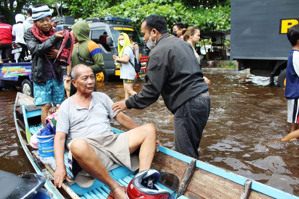 Warga lansia menjadi prioritas utama untuk diungsikan, termasuk Untung (68). Pensiunan PNS Kota Palangkaraya ini harus digotong menggunakan perahu kayu karena rumahnya terendam banjir dengan ketinggian hampir 1 meter pada Senin (15/11/2021).