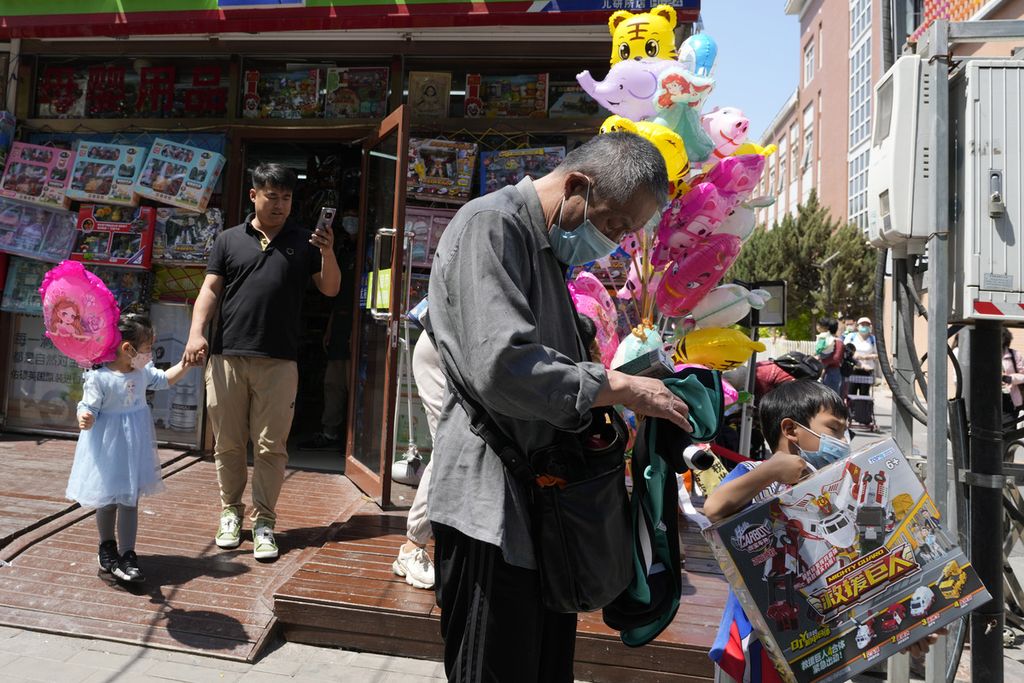 Anak-anak mengunjungi toko mainan di luar rumah sakit anak di Beijing, Senin (8/5/2023). 