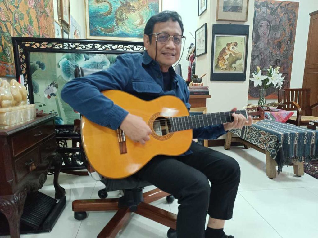 Staf Khusus Kepresidenan Sukardi Rinakit bermain gitar untuk mengisi waktu luang, Jumat (1/12/2023). 