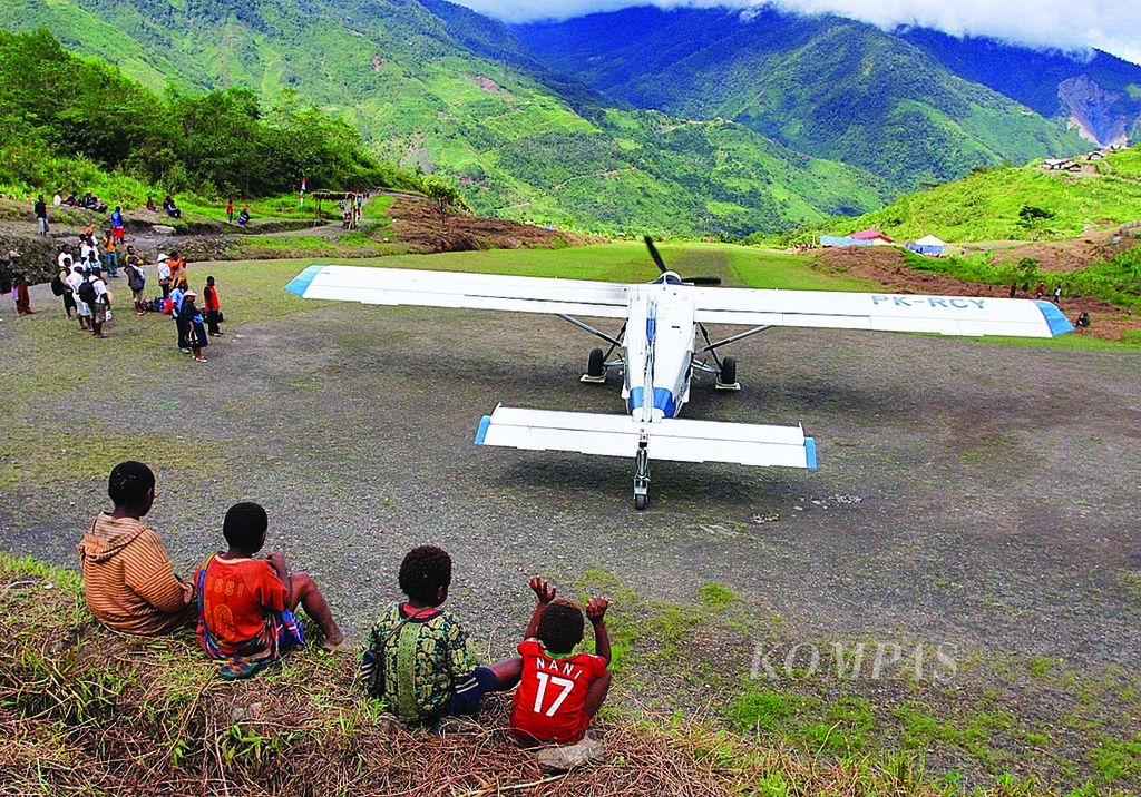 Anak-anak warga Distrik Oklip, Kabupaten Pegunungan Bintang Papua tengah menyaksikan pesawat perintis milik AMA, Selasa (13/12/2011). Pesawat-pesawat perintis seperti itulah yang menjadi penghubung wilayah pedalaman Papua. 