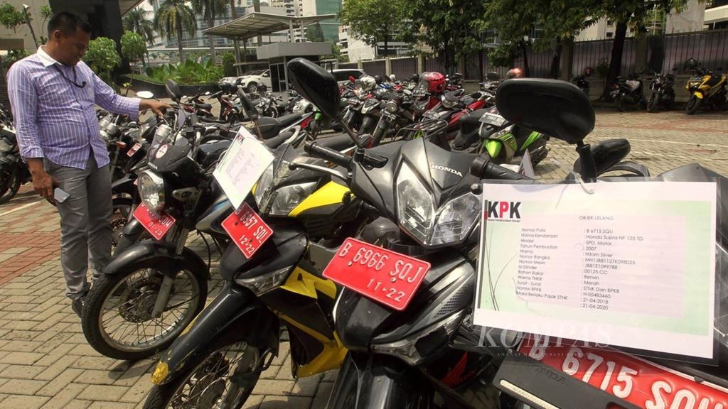 Petugas internal dalam KPK memeriksa surat keterangan kendaraan lelang inventaris KPK yang ada di Gedung KPK, C-1 Jakarta.