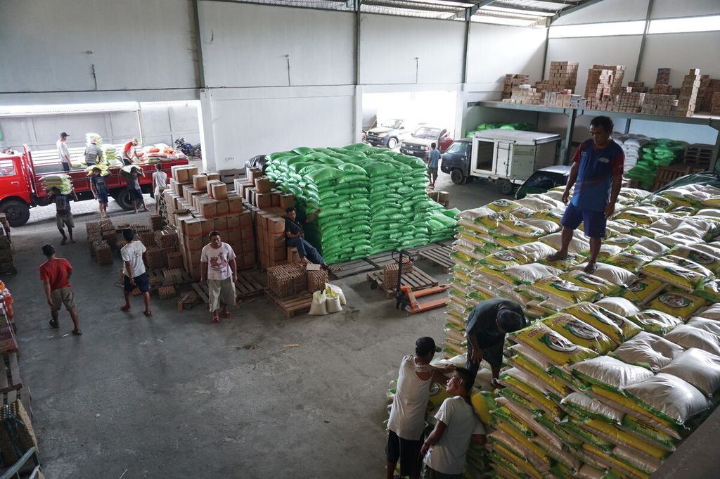 Para pekerja mengangkut karung-karung beras.