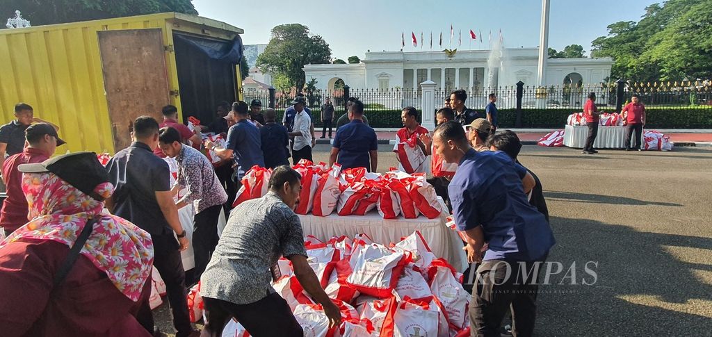 Petugas menata paket bahan pangan dari Presiden Joko Widodo yang akan dibagikan kepada warga di depan Istana Merdeka, Jakarta, Senin (8/4/2024).