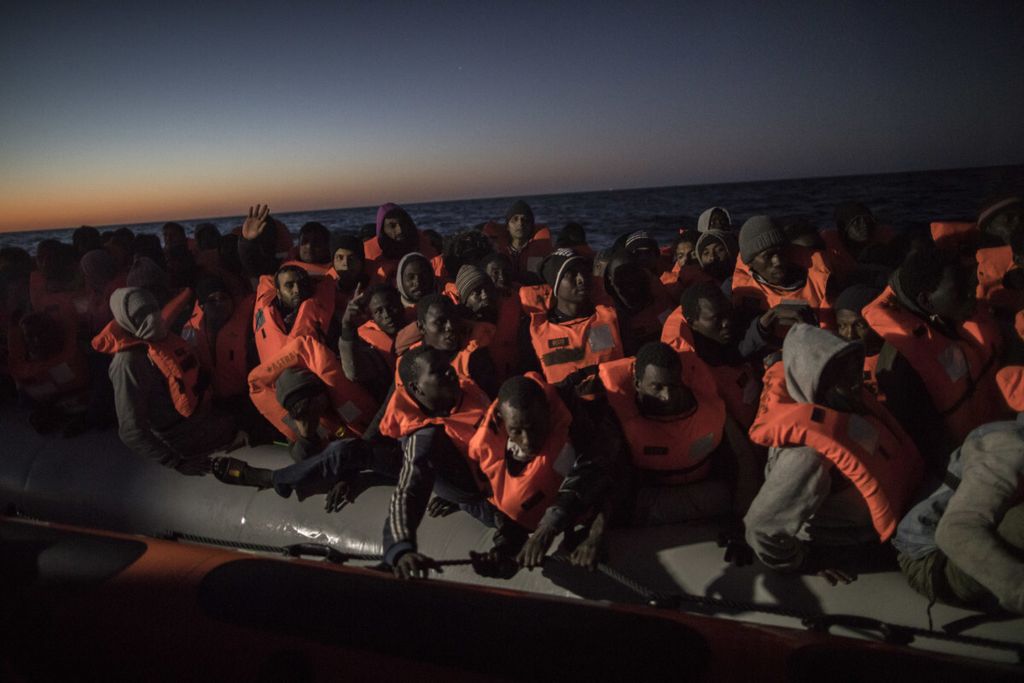 Arsip foto per 16 Januari 2018 ini menunjukkan para pengungsi dari sejumlah negara Sub-Sahara berusaha meninggalkan pantai Libya menuju Eropa menggunakan kapal karet. Mereka diselamatkan tim dari lembaga swadaya masyarakat Spanyol, Proactiva Open Arms.