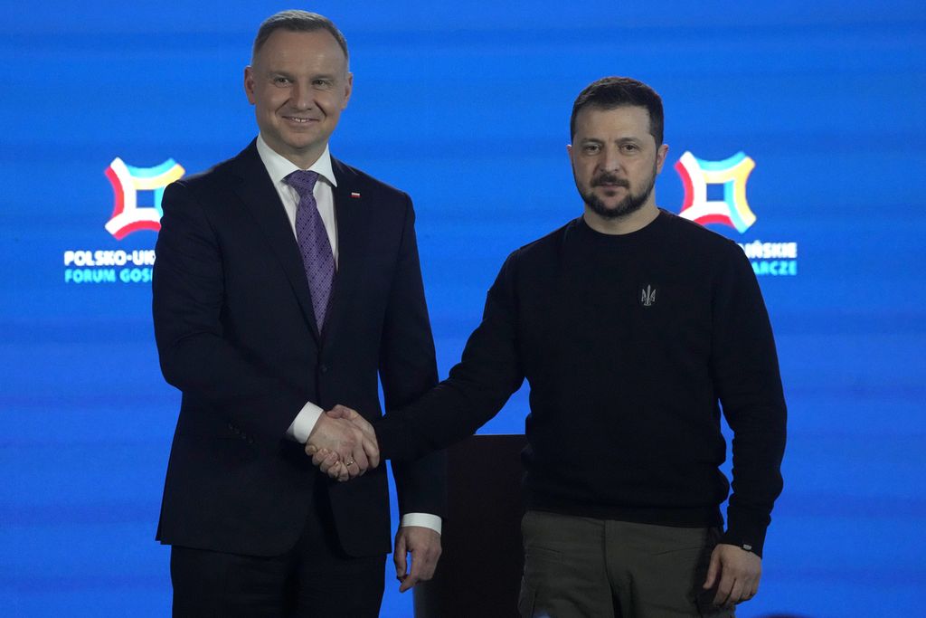 Presiden Polandia Andrzej Duda (kiri) dan Presiden Ukraina Volodymyr Zelenskyy berjabat tangan dalam sebuah forum ekonomi di Warsawa, 5 April 2023. 