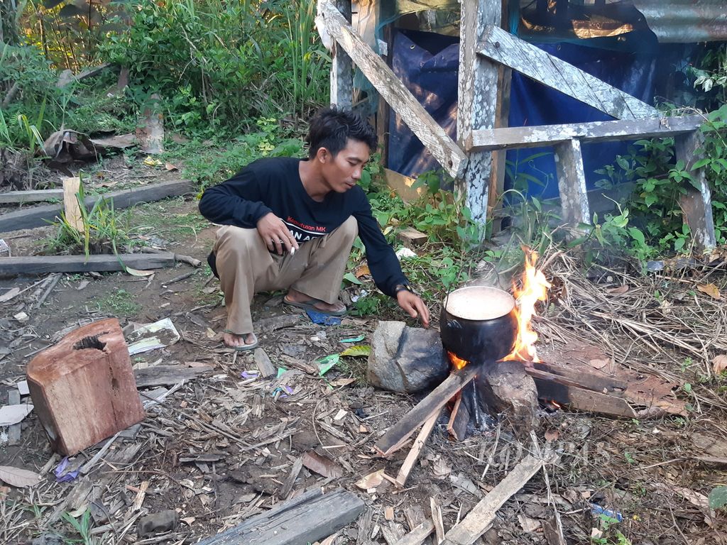 Seorang warga memasak di samping rumahnya di Kampung Mului, Desa Swan Slotung, Kecamatan Muara Komam, Kabupaten Paser, Kalimantan Timur, Rabu (22/11/2023).