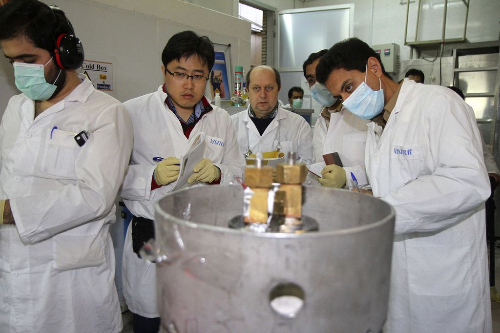 Para inspektor dari IAEA dan teknisi Iran bersiap memotong koneksi di antara dua mesin pemutar untuk pengayaan uranium 20 persen di situs Natanz, Iran, 20 Januari 2014. 
