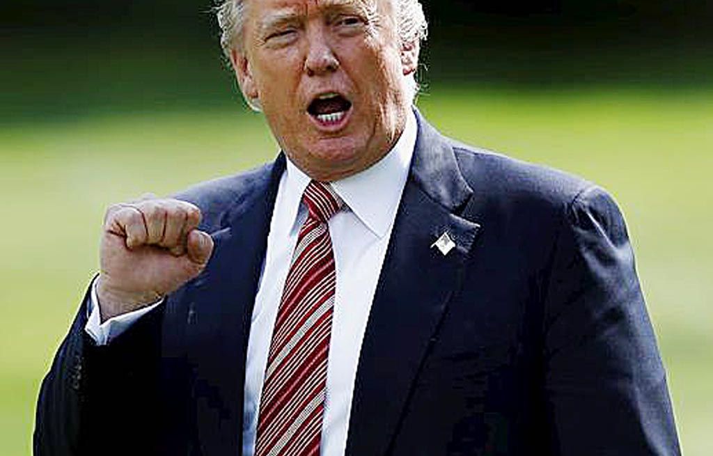 Presiden Amerika Serikat  Donald Trump memperlihatkan isyarat kepalan tangan ke arah awak media, Jumat (25/8), saat akan meninggalkan Gedung Putih menuju Camp David. 